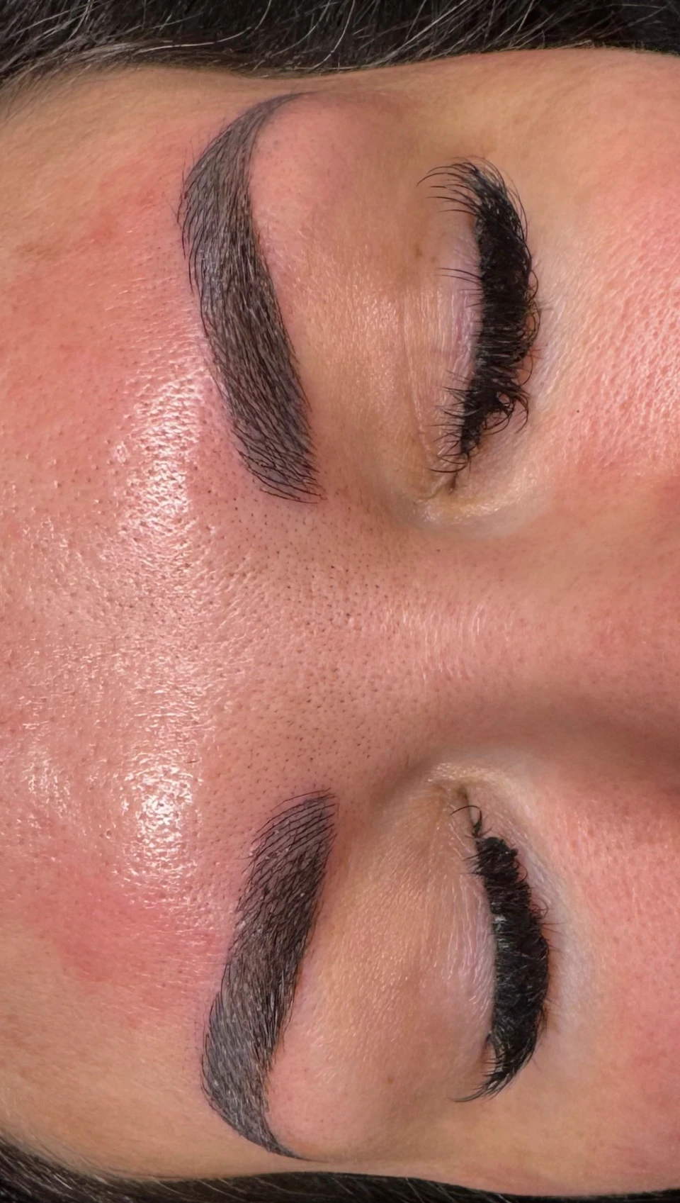 Close view of both eyebrows showing individual strokes and curved arches.